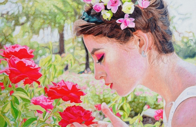 A young girl enjoying the fragrance of roses in the garden